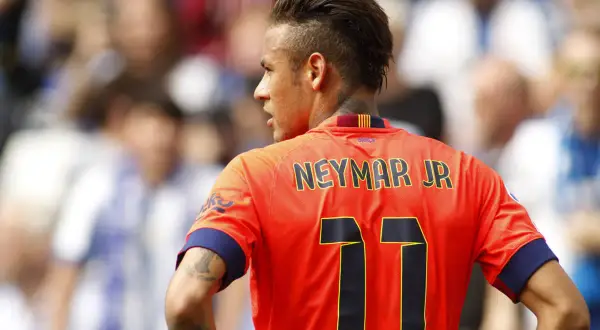 Neymar w Barcelonie, w pomarańczowej koszulce z numerem 11, na tle trybun.