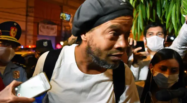 Ronaldinho w otoczeniu policji i tłumu, z telefonami skierowanymi na niego. Słynny piłkarz, którego losy potoczyły się w nieoczekiwany sposób, w tym do więzienia.