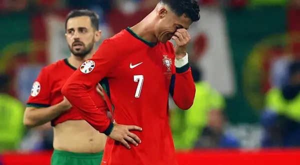 Cristiano Ronaldo, z jakiego kraju jest Ronaldo, w koszulce Portugalii z numerem 7, ociera łzy.