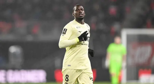 Piłkarz w żółtej koszulce z numerem 8, gdzie gra Pogba, biegnie po boisku w deszczu.