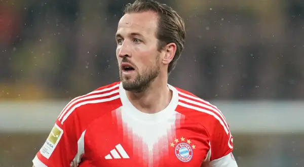 Piłkarz w czerwonej koszulce Bayernu Monachium, Harry Kane, wygląda na zaniepokojonego, być może z powodu kontuzji.