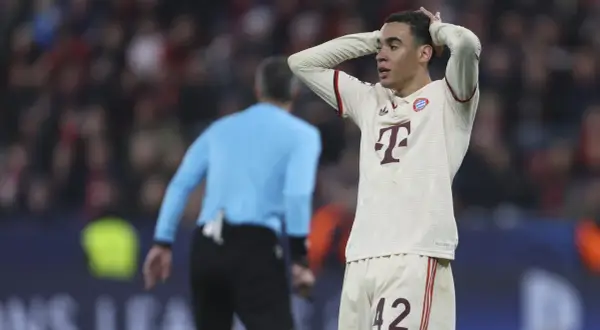 Jamal Musiala, piłkarz Bayernu, z rękami na głowie, wyraża frustrację na boisku.