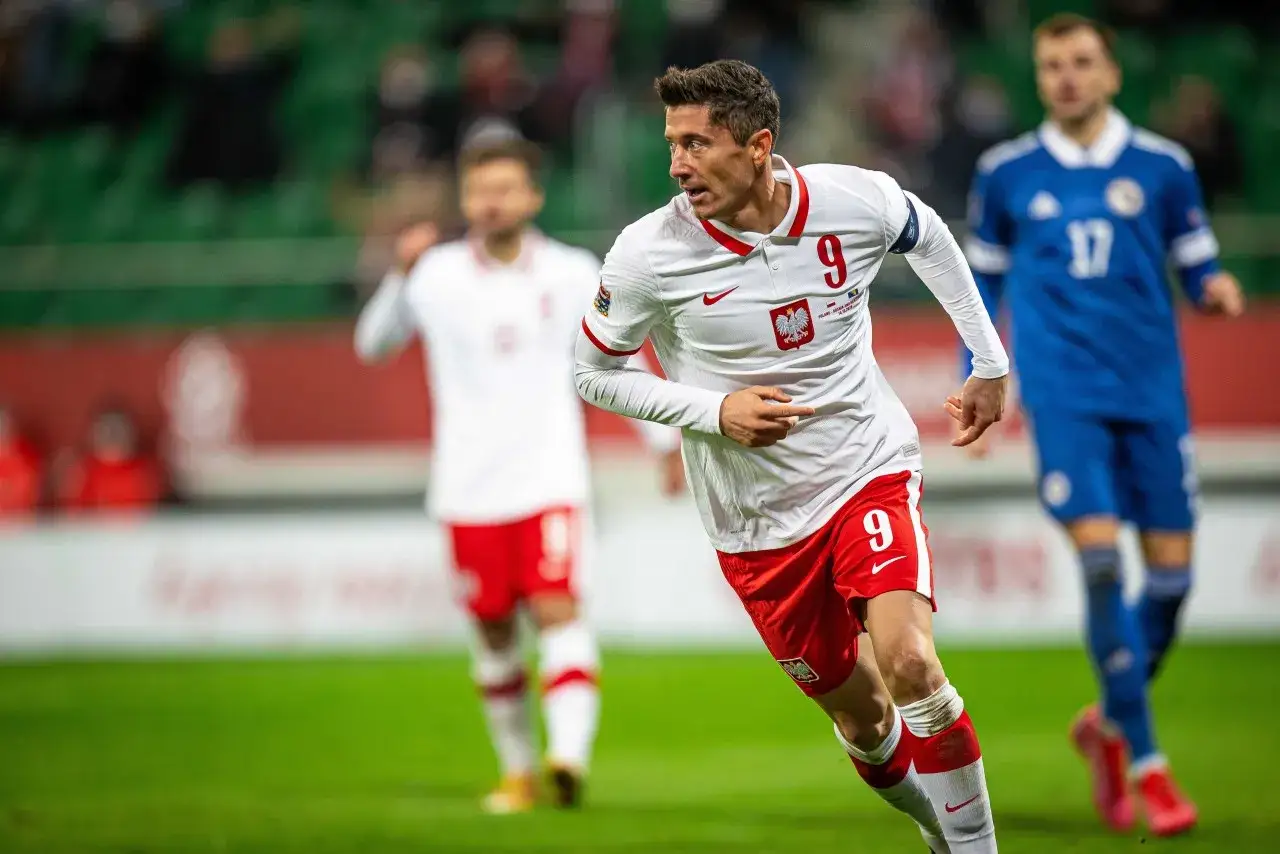 Robert Lewandowski w akcji, biegnie po boisku w koszulce z numerem 9. Najnowsze informacje o jego karierze.