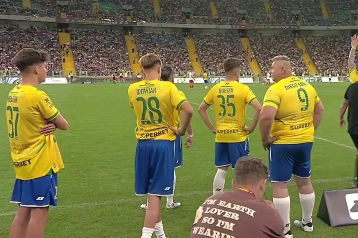 Piłkarze w żółtych koszulkach na boisku. Jeden z nich, Diego Sousa, brazylijski piłkarz, ma numer 9.