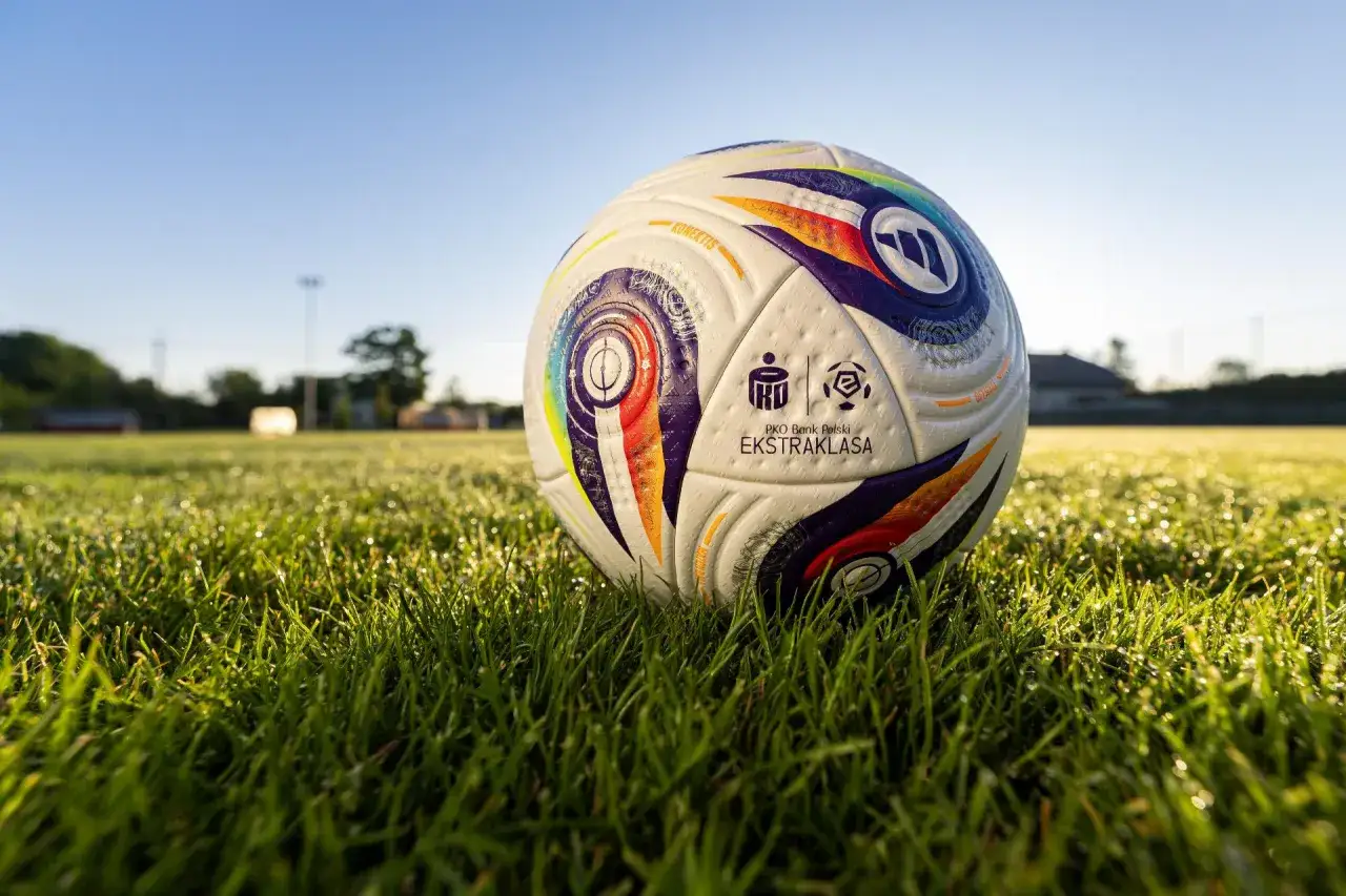 Piłka do piłki nożnej PKO Bank Polski Ekstraklasa leży na mokrej trawie. Czekamy na początek ekstraklasy!