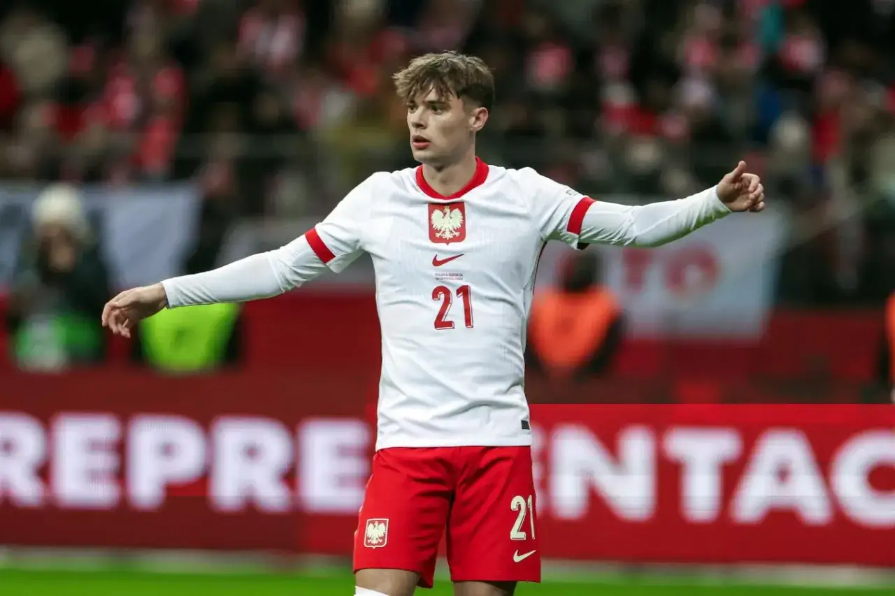 Piłkarz Nicola Zalewski, numer 21, w białej koszulce reprezentacji Polski. Jego wiek to młodość i talent.