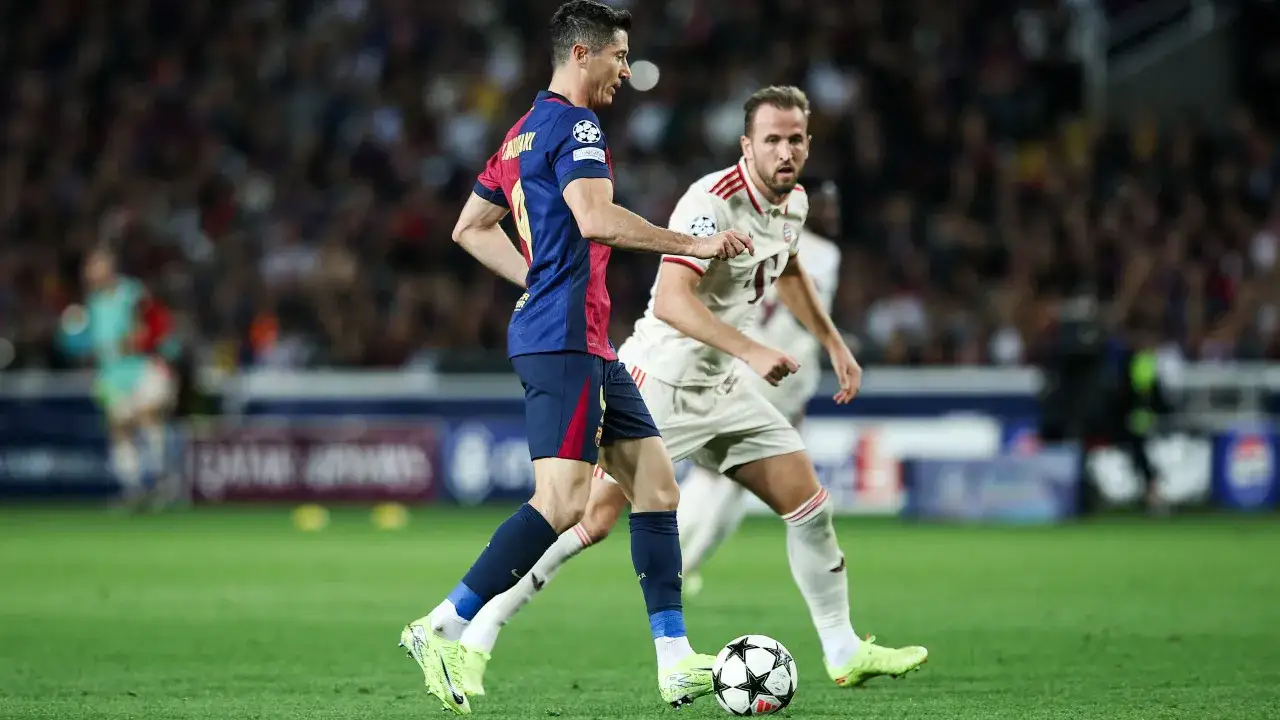 Piłkarze FC Barcelony i Bayernu Monachium walczą o piłkę. Robert Lewandowski drybluje, a Harry Kane próbuje go zatrzymać, mimo że jego kane kontuzja mogła go spowolnić.