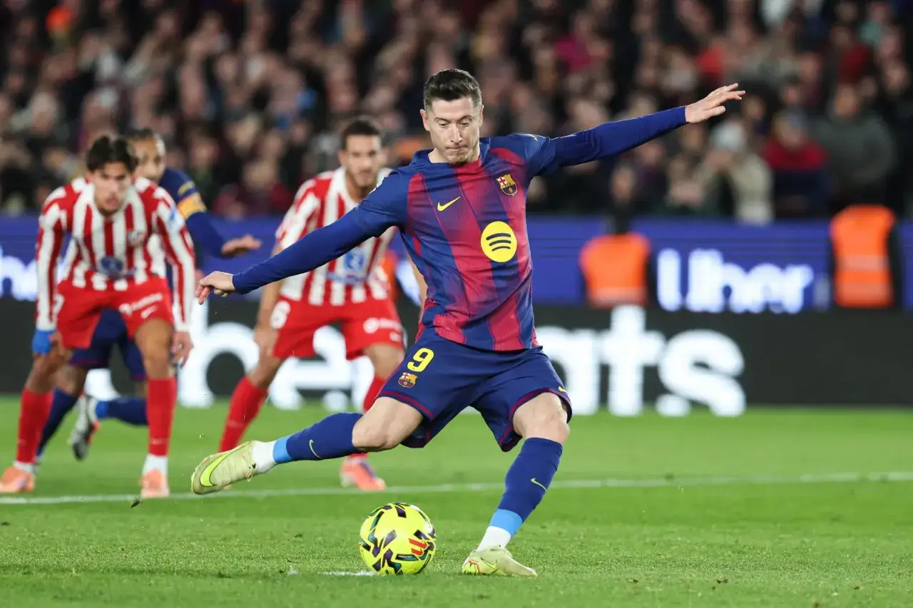 Robert Lewandowski wykonuje rzut karny, celując w bramkę.