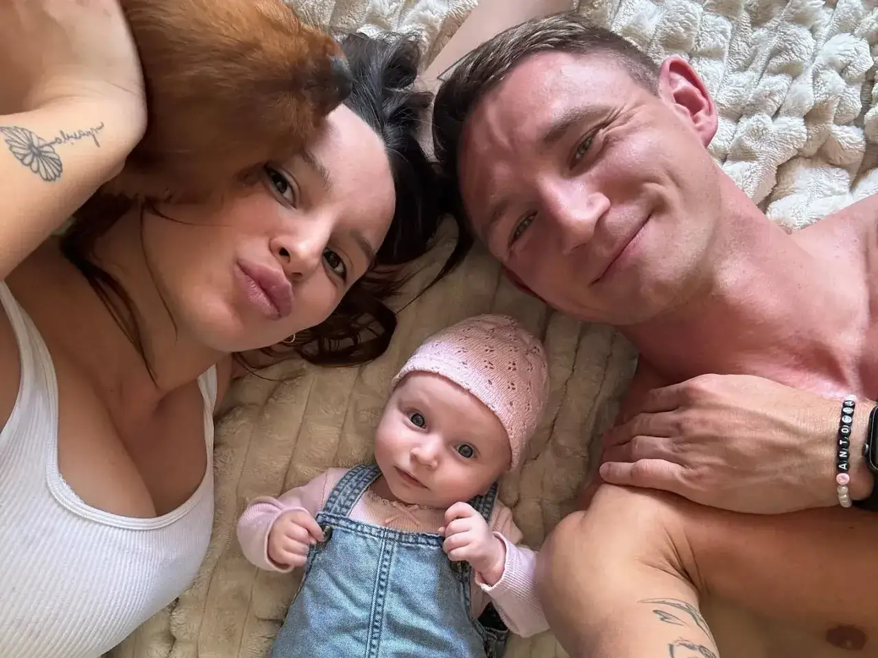 Rodzina Jakub Rzeźniczak dzieci: mama, tata i ich mała córeczka leżą razem na łóżku.