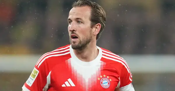 Piłkarz w czerwonej koszulce Bayernu Monachium, Harry Kane, wygląda na zaniepokojonego, być może z powodu kontuzji.